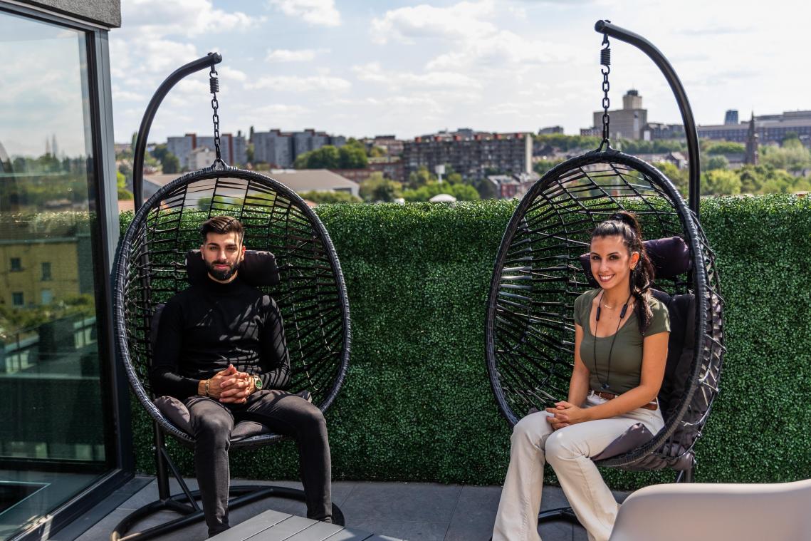 Fauteuils suspendus sur la terrasse, vue sur les toits de Charleroi