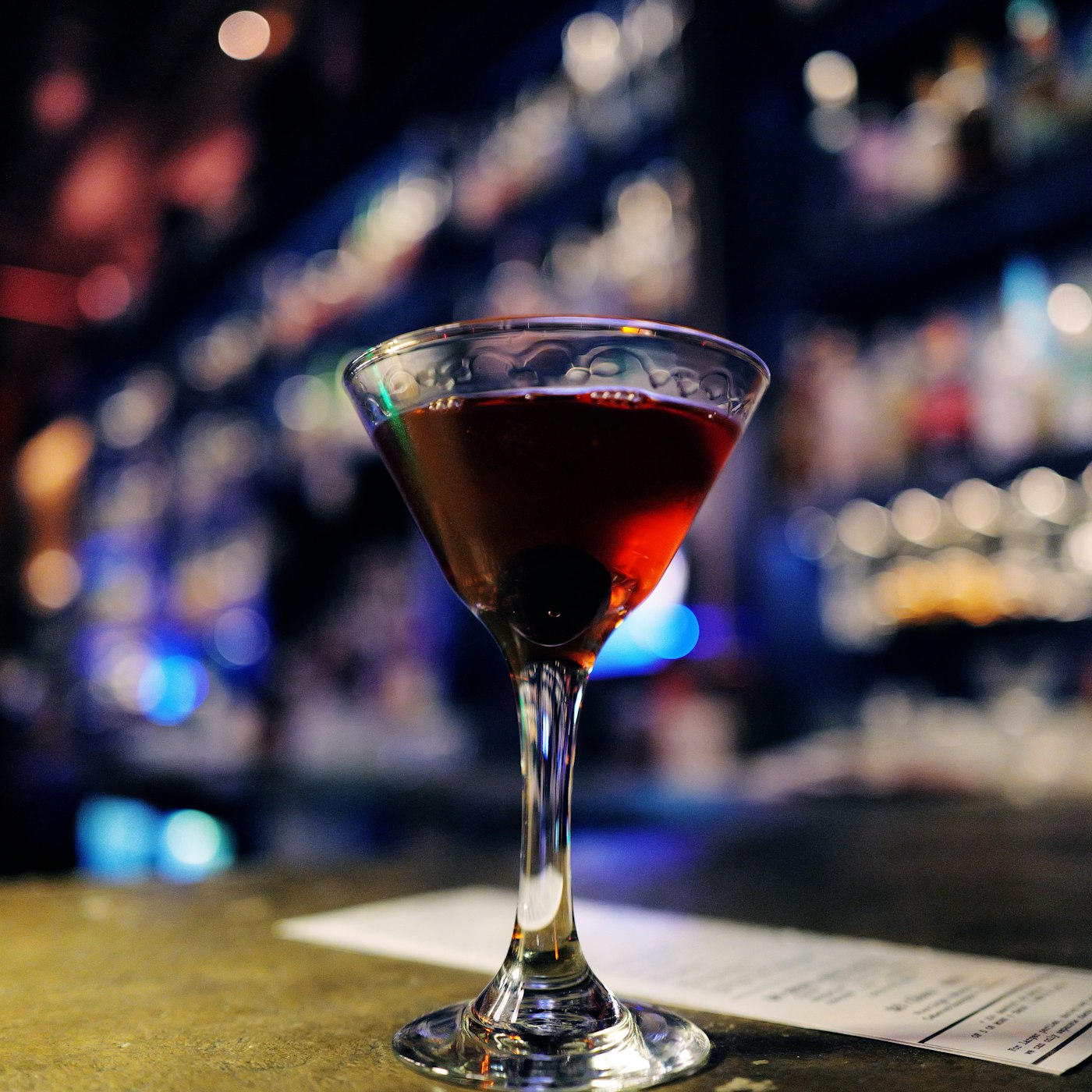Cocktail sombre servi dans un verre à pied