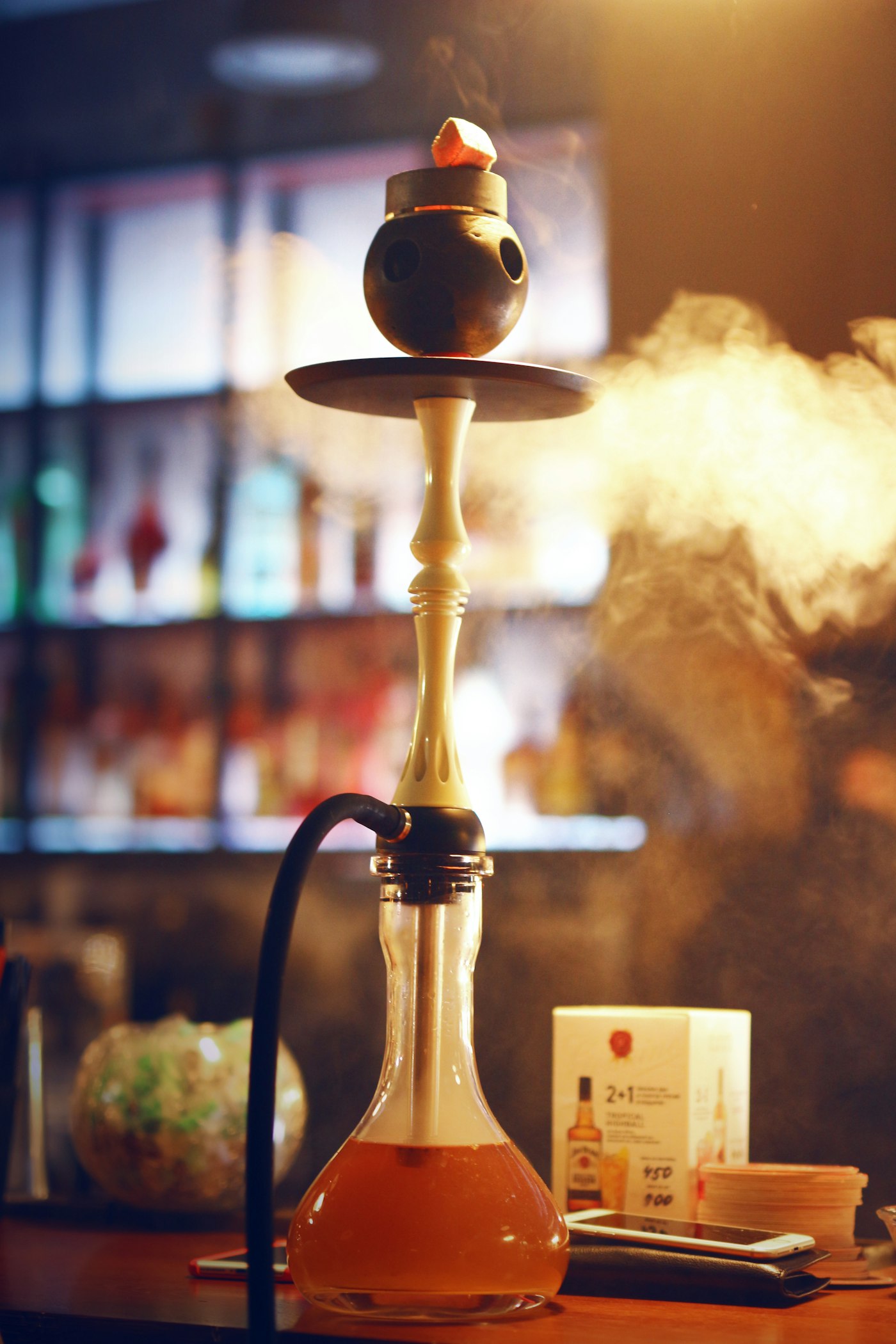 Chicha allumée, volutes de fumée dans la pénombre